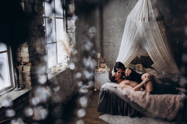 Genç ve seksi bir çift yatakta poz veriyor..