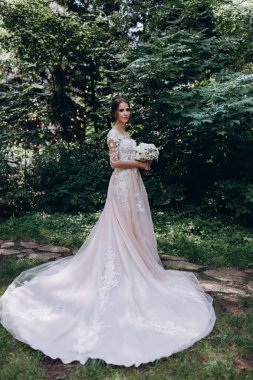 Beyaz elbiseli güzel gelin elinde düğün buketi                 