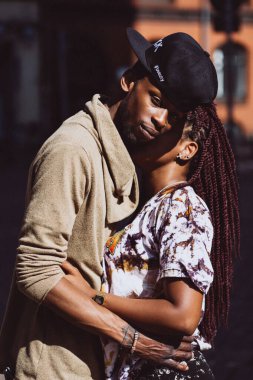 Afrikalı çift sokakta öpüşüyor ve sarılıyor.