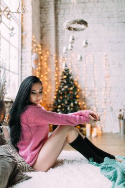 Noel arifesinde süveter giyen genç ve güzel bir kadın.