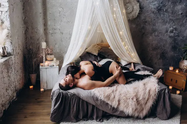 Mutlu romantik çift yatakta uzanıp öpüşüyor.