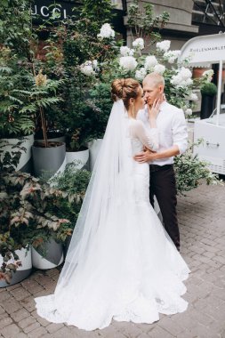 Mutlu çift gelin ve damat şehirde düğün günü sarılıp öpüşüyor..         