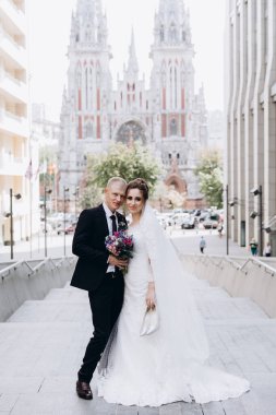 Güzel mutlu gelin ve damat şehirde yürüyor.         