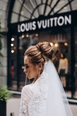 Beyaz gelinlik içinde sokakta poz veren güzel bir gelin.