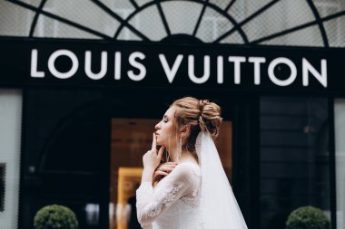 Louis Vuitton Louis Vuitton yakınlarında beyaz gelinlik içinde poz veren güzel bir gelin.