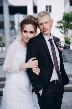 Güzel bir çift mutlu gelin ve damat şehirde birlikte poz veriyorlar.               