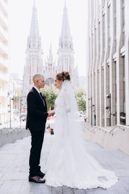 Güzel mutlu gelin ve damat şehirde yürüyor.         