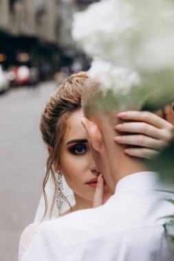 Güzel bir çift mutlu gelin ve damat şehirde birlikte poz veriyorlar.               