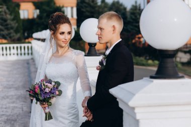 Güzel mutlu gelin ve damat şehirde yürüyor.         