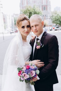 Güzel bir çift mutlu gelin ve damat şehirde birlikte poz veriyorlar.               