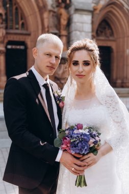 Güzel bir çift mutlu gelin ve damat şehirde birlikte poz veriyorlar.               