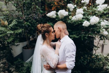 Mutlu çift gelin ve damat şehirde düğün günü sarılıp öpüşüyor..         