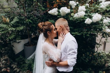 Mutlu çift gelin ve damat şehirde düğün günü sarılıp öpüşüyor..         