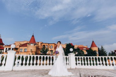 Şehirde poz veren zarif beyaz gelinlik içindeki güzel genç gelinin portresi.          