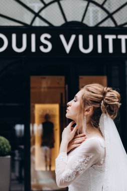 Louis Vuitton Louis Vuitton yakınlarında beyaz gelinlik içinde poz veren güzel bir gelin.