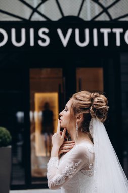 Louis Vuitton Louis Vuitton yakınlarında beyaz gelinlik içinde poz veren güzel bir gelin.