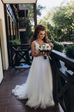 Mutlu genç gelin elinde bir buket çiçek tutuyor   