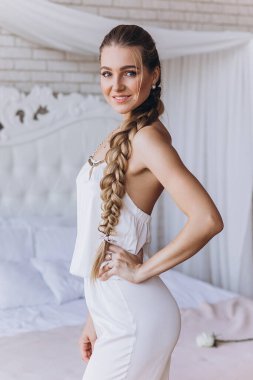 Yatak odasında güzel saç stili olan çekici genç bir kadın.      