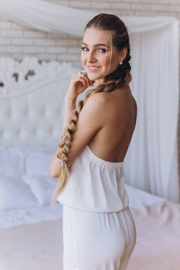 Yatak odasında güzel saç stili olan çekici genç bir kadın.      