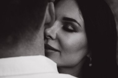 Siyah-beyaz öpüşen genç çifte yakın durun. 