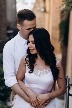 Genç ve güzel bir çift eski şehirde birbirlerine sarılıp poz veriyorlar.     