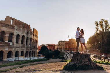 Tarihi Kolezyum harabelerinin önünde çift kucaklaşıyor