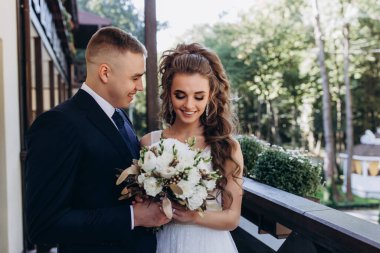 Genç bir düğün çifti güneşli bir günde romantik bir anın tadını çıkarır..