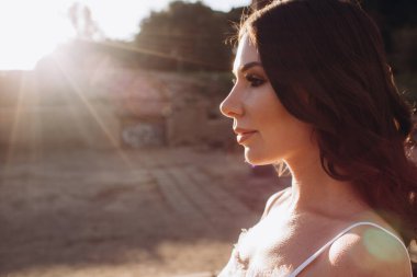 Günbatımının arka planında beyaz elbiseli güzel bir kız