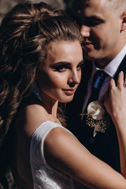 Genç bir düğün çifti güneşli bir günde romantik bir anın tadını çıkarır..