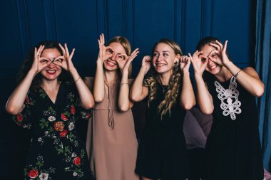 Genç ve güzel kadınlar elleriyle komik suratlar yapıyor.