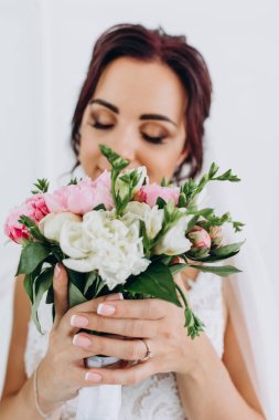 Güzel bir düğün buketi tutan genç gelinin yakın çekimi.