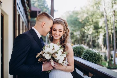 Genç bir düğün çifti güneşli bir günde romantik bir anın tadını çıkarır..