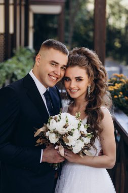 Mutlu genç gelin ve damat kameraya gülümsüyor