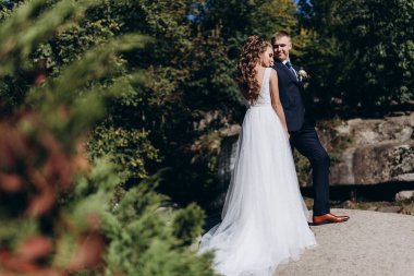 Güzel bir parkta birlikte yürüyen mutlu genç bir çift.