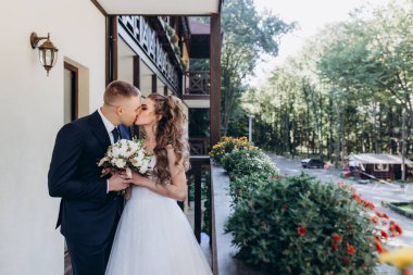 Güzel, mutlu bir çift terasta öpüşüyor ve sarılıyor. 