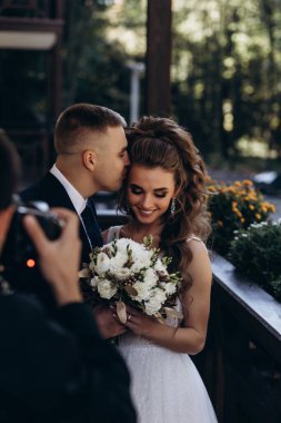 Güzel, mutlu bir çift terasta öpüşüyor ve sarılıyor. 