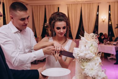 Gelin ve damat restoranda lezzetli bir düğün pastası kesiyorlar.. 