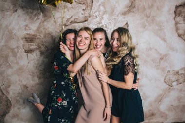 Stüdyoda balonlarla poz veren şenlikli elbiseli güzel genç kızlar.