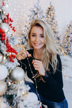 Noel ağacı olan çekici, mutlu genç bir kadın.