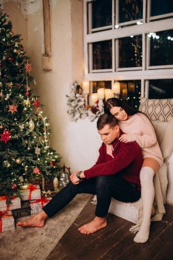 Birbirlerine aşık genç bir çift stüdyoda rahat bir Noel süslemesiyle poz veriyorlar. Yeni yılın aşk hikayesi.. 