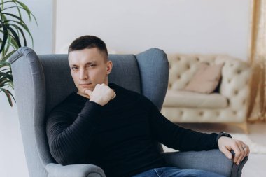 Genç adam stüdyoda poz verirken gündelik kıyafetler giyiyor.. 