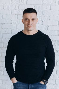 Genç adam stüdyoda poz verirken gündelik kıyafetler giyiyor.. 