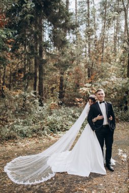 Güzel, mutlu, genç bir çift ormanda poz veriyor.                