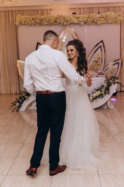 Genç gelin ve damat düğün resepsiyonunda dans ediyor.