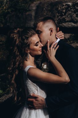 Dağda genç bir çift dışarıda öpüşüyor.