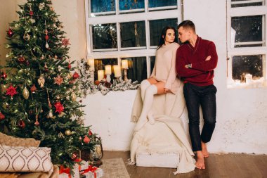 Birbirlerine aşık genç bir çift stüdyoda rahat bir Noel süslemesiyle poz veriyorlar. Yeni yılın aşk hikayesi.. 