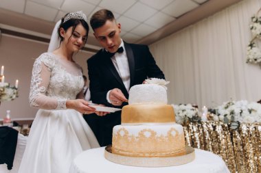 Mutlu gelin ve damat düğün pastasını kesiyor. 