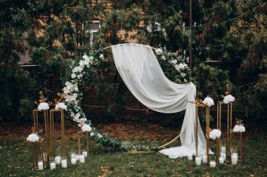 Çiçekler, mumlar ve beyaz perdelerle süslenmiş düğün alanı.. 