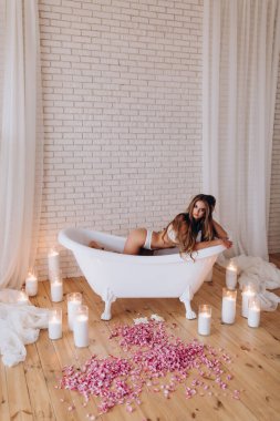 Stüdyoda beyaz küvette poz veren beyaz bir kadın. fotoğraf çekimi 