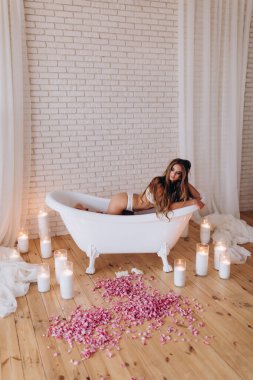 Stüdyoda beyaz küvette poz veren beyaz bir kadın. fotoğraf çekimi 